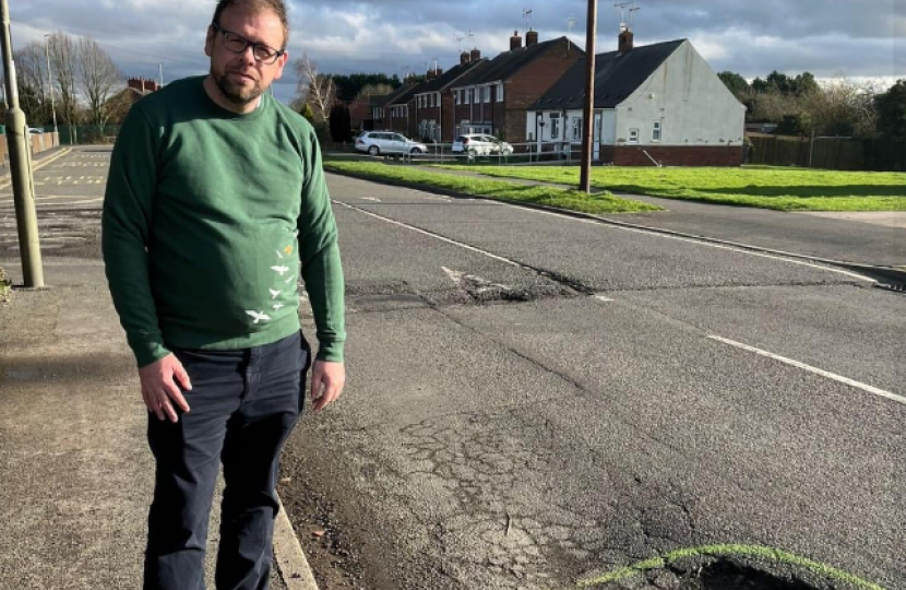 mark standing by a pot hole before it was fixed